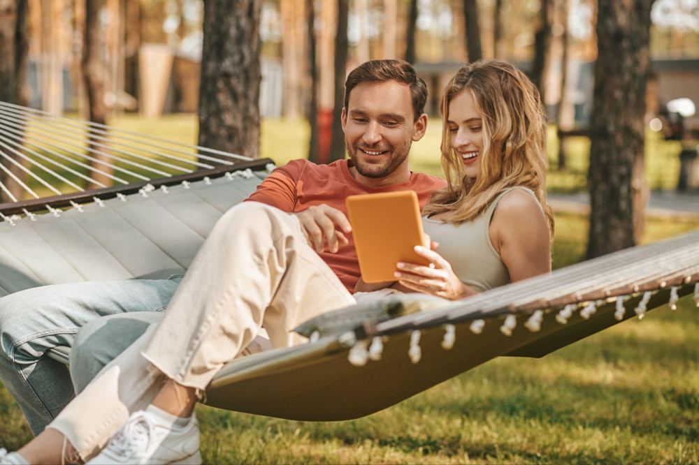 Pareja usando una tablet en una hamaca